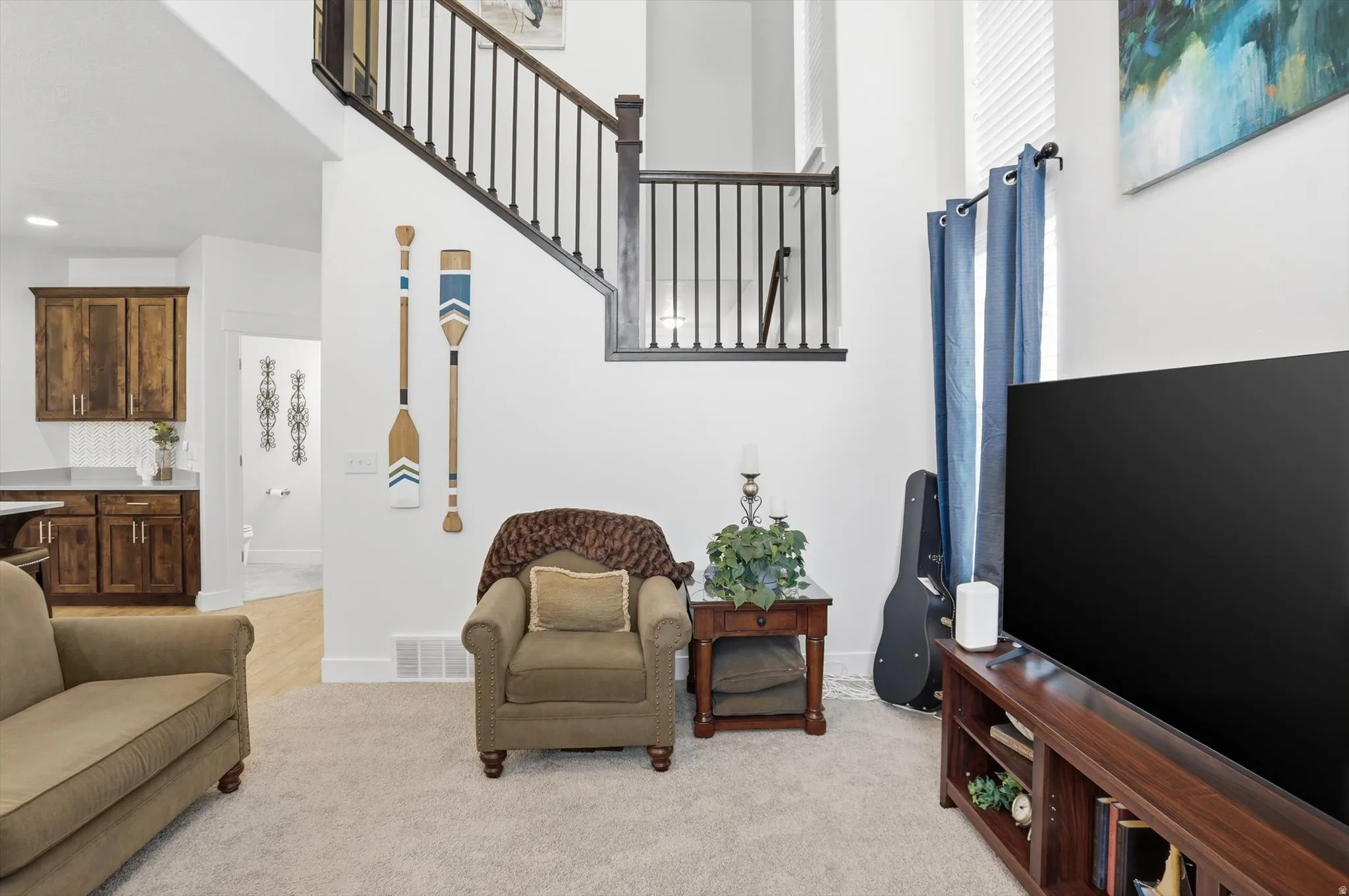 Living area featuring light carpet and a high ceiling
