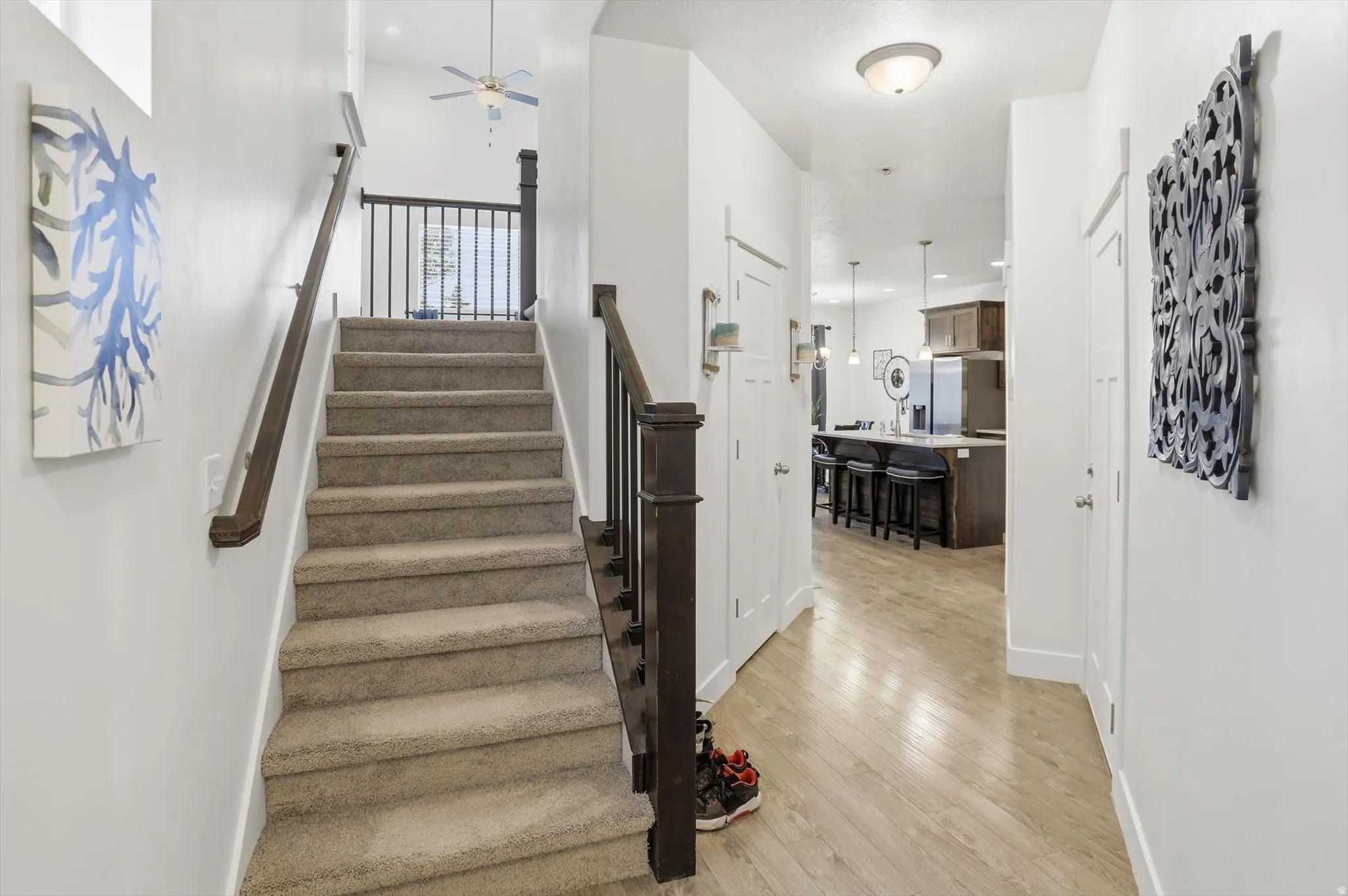 Stairs with ceiling fan and wood finished floors