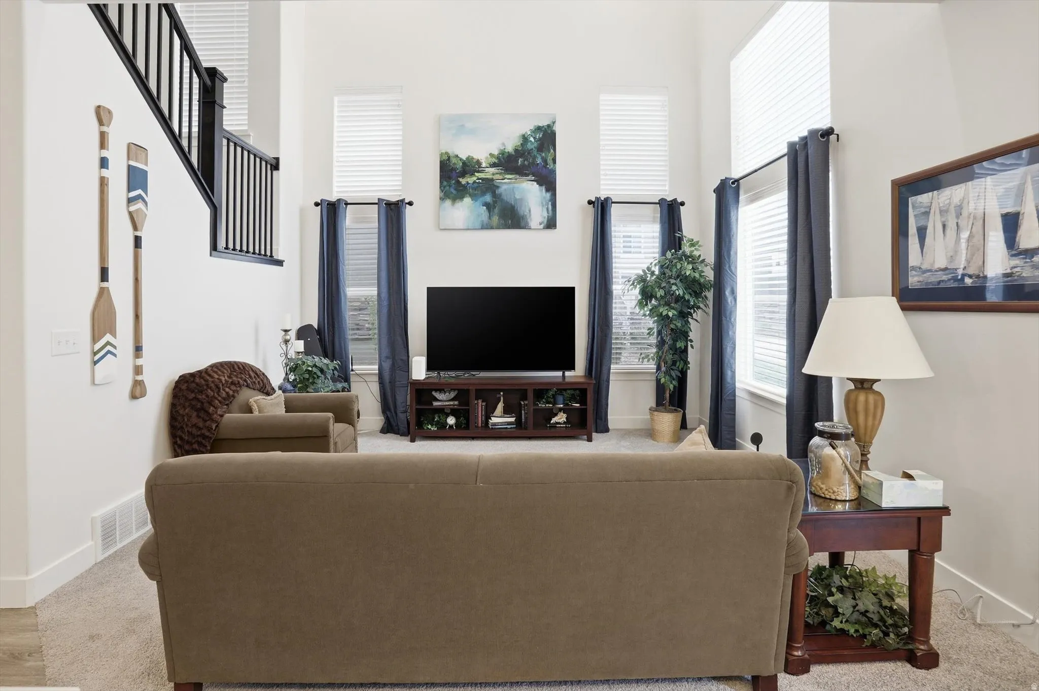 Living room featuring a high ceiling and light colored carpet
