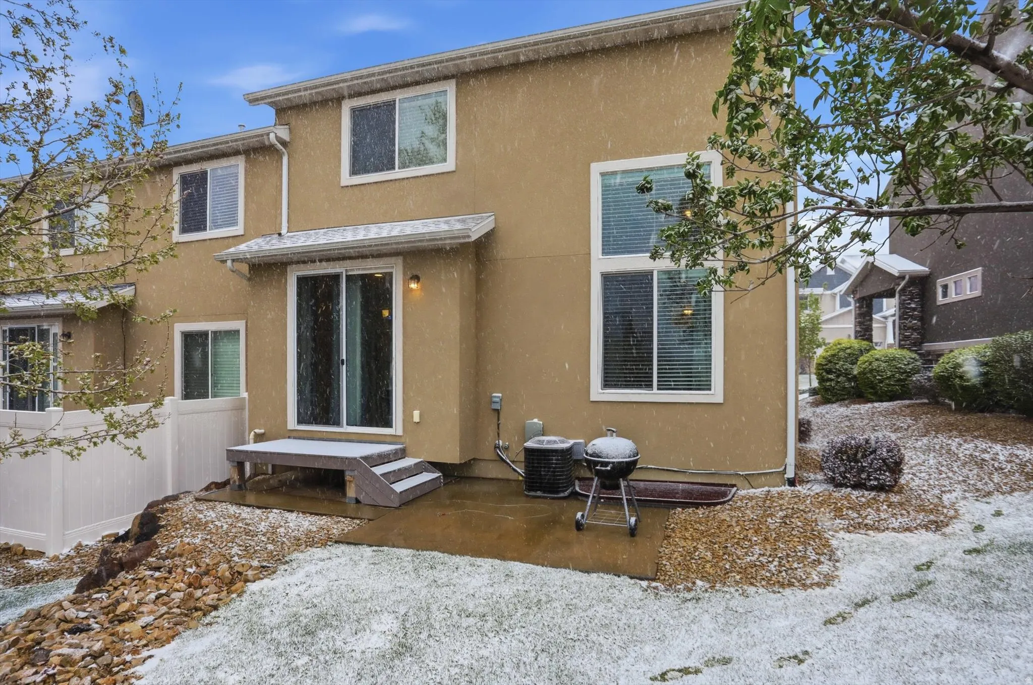 Snow covered back of property featuring stucco siding