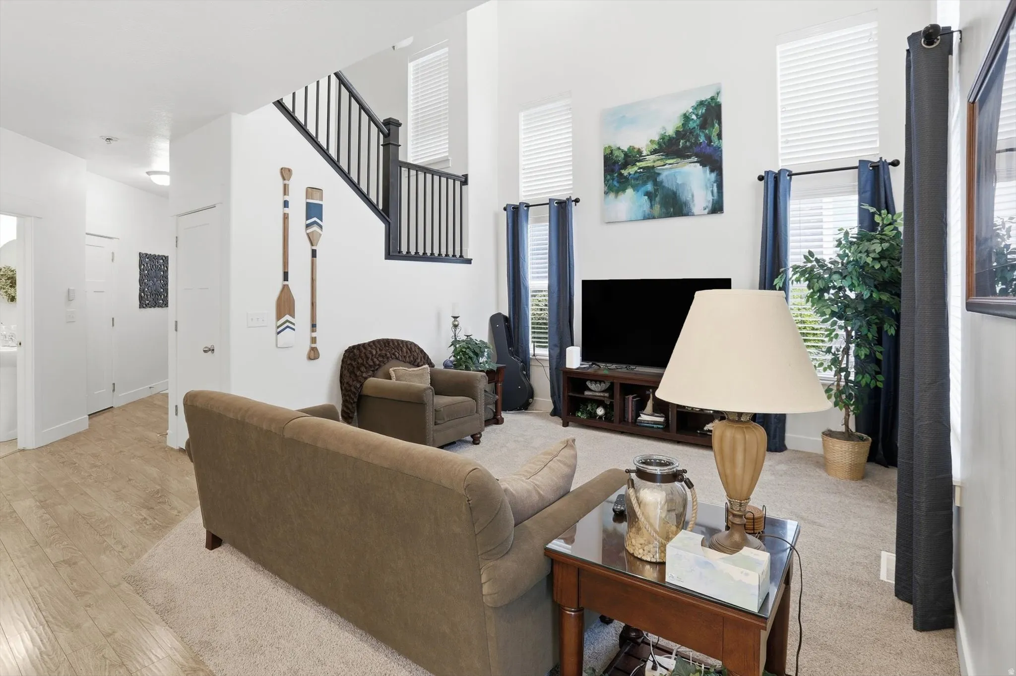 Living area featuring light wood-type flooring and a high ceiling