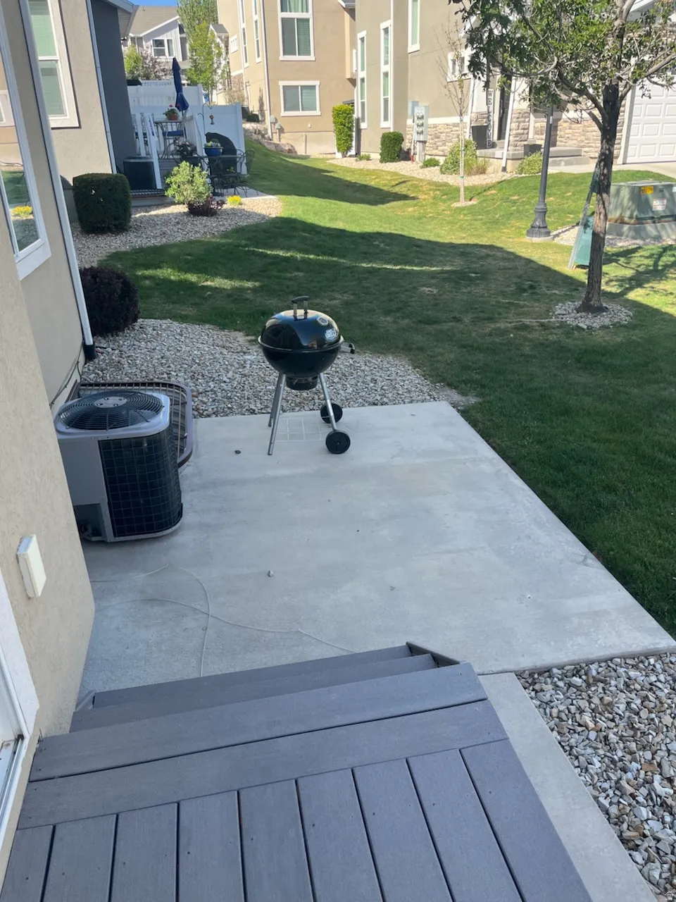 Ground-level patio with steps leading to a gravel and lawn area