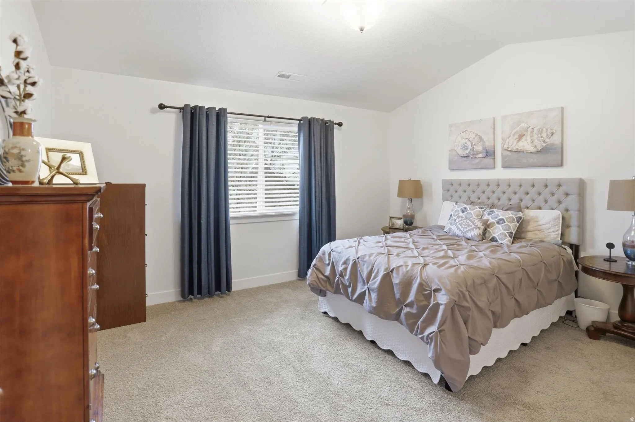 Bedroom featuring lofted ceiling and light carpet