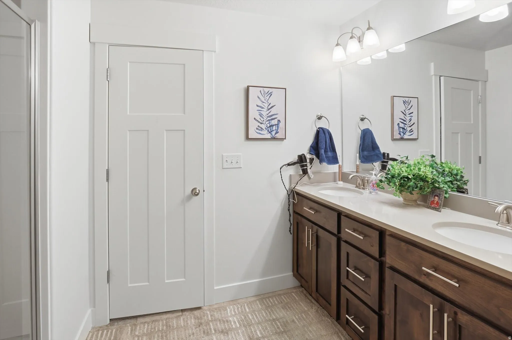 Full bath featuring double vanity and baseboards
