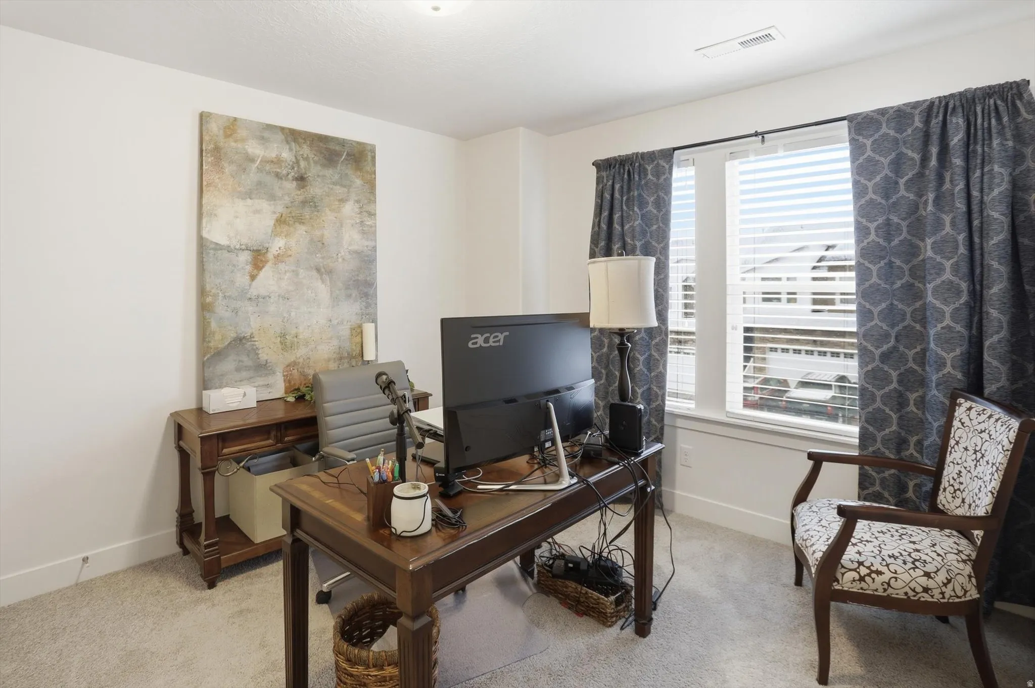 Home office with light carpet and baseboards