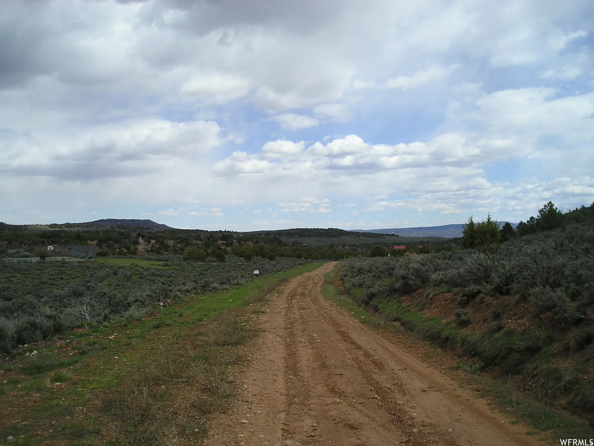 View of dirt / gravel road featuring a rural view and a mountain view