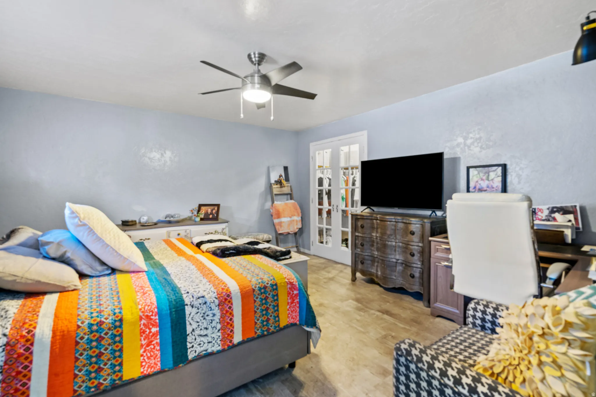 Bedroom with a ceiling fan, french doors, and light wood finished floors