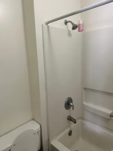 Bathroom with toilet and bathing tub / shower combination