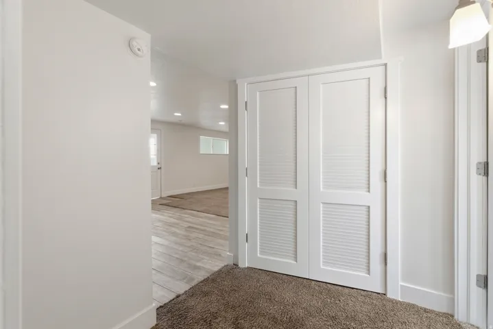 Corridor with light carpet and recessed lighting