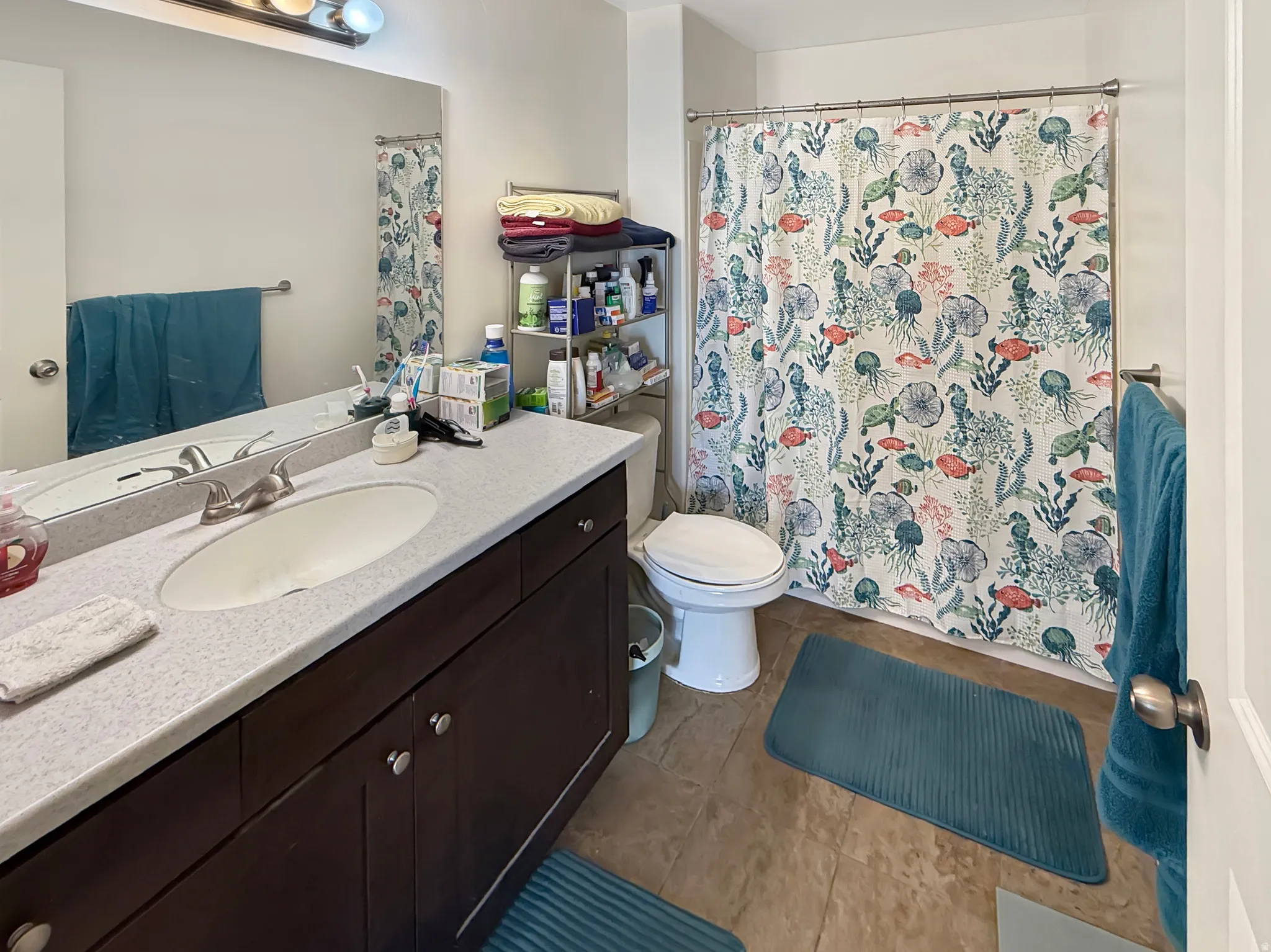 Bathroom featuring vanity, a shower with shower curtain, and light tile patterned flooring