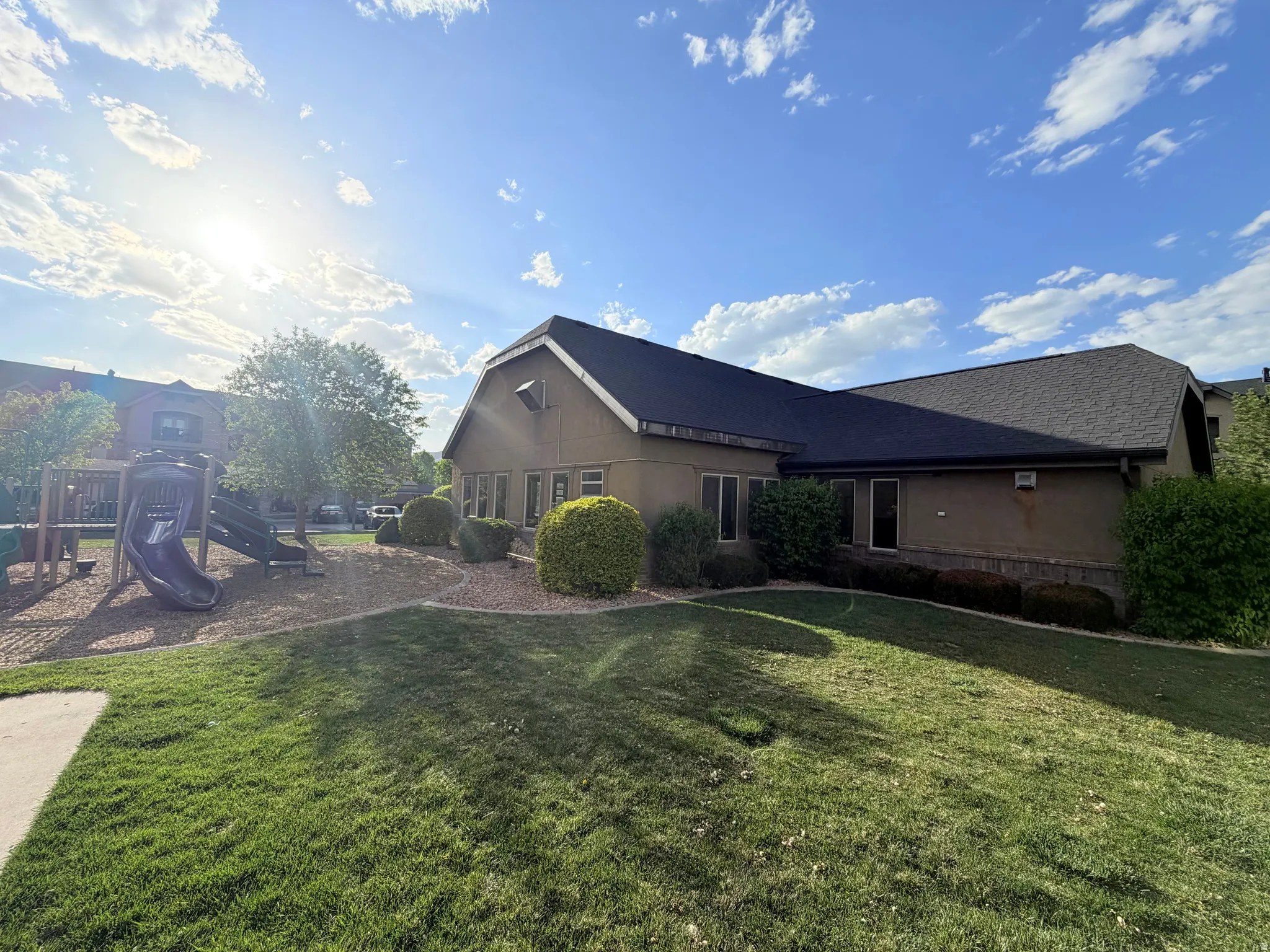 View of home's exterior with a playground and a yard