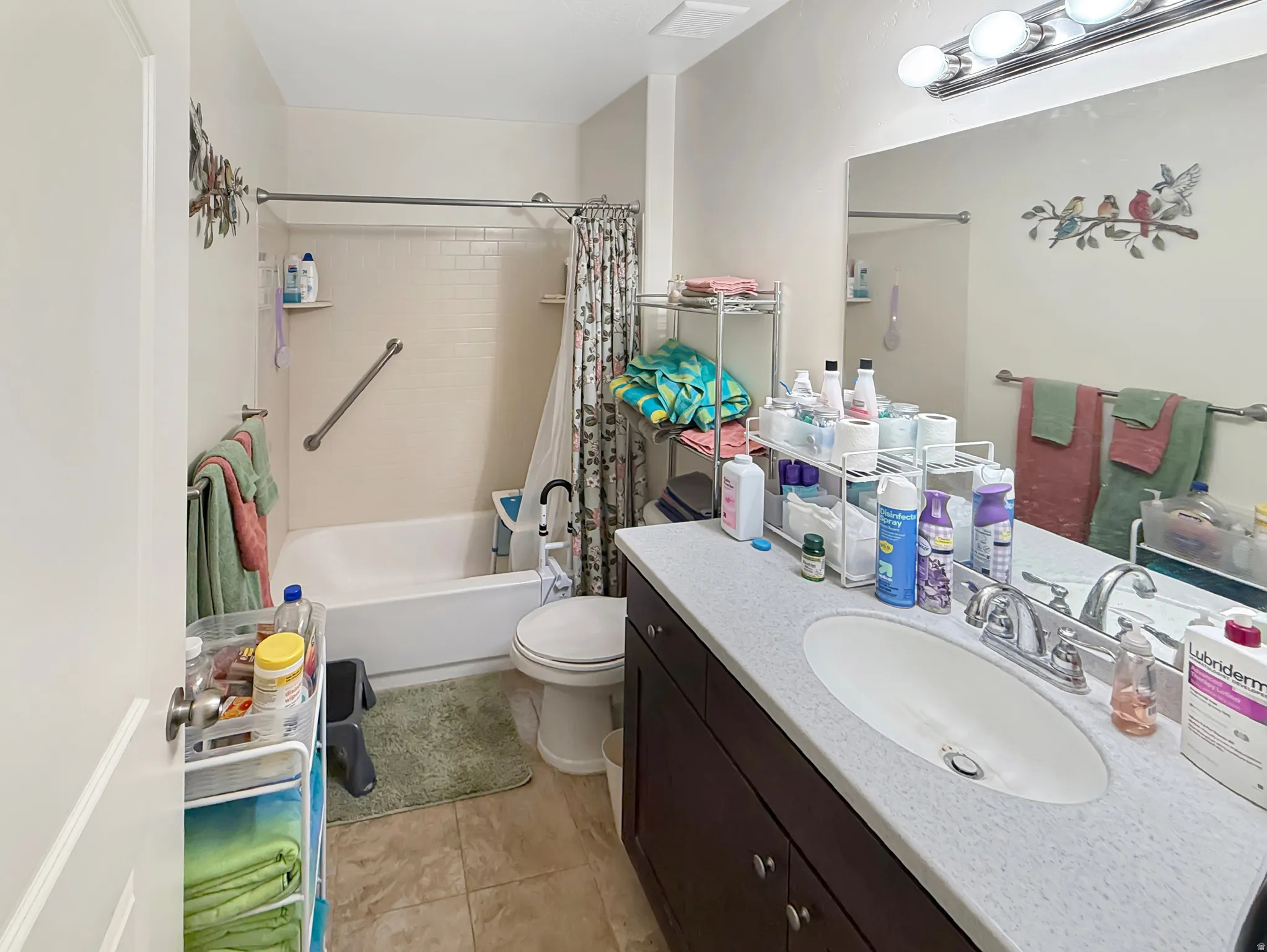 Full bathroom with vanity, shower / bath combo, and light tile patterned floors