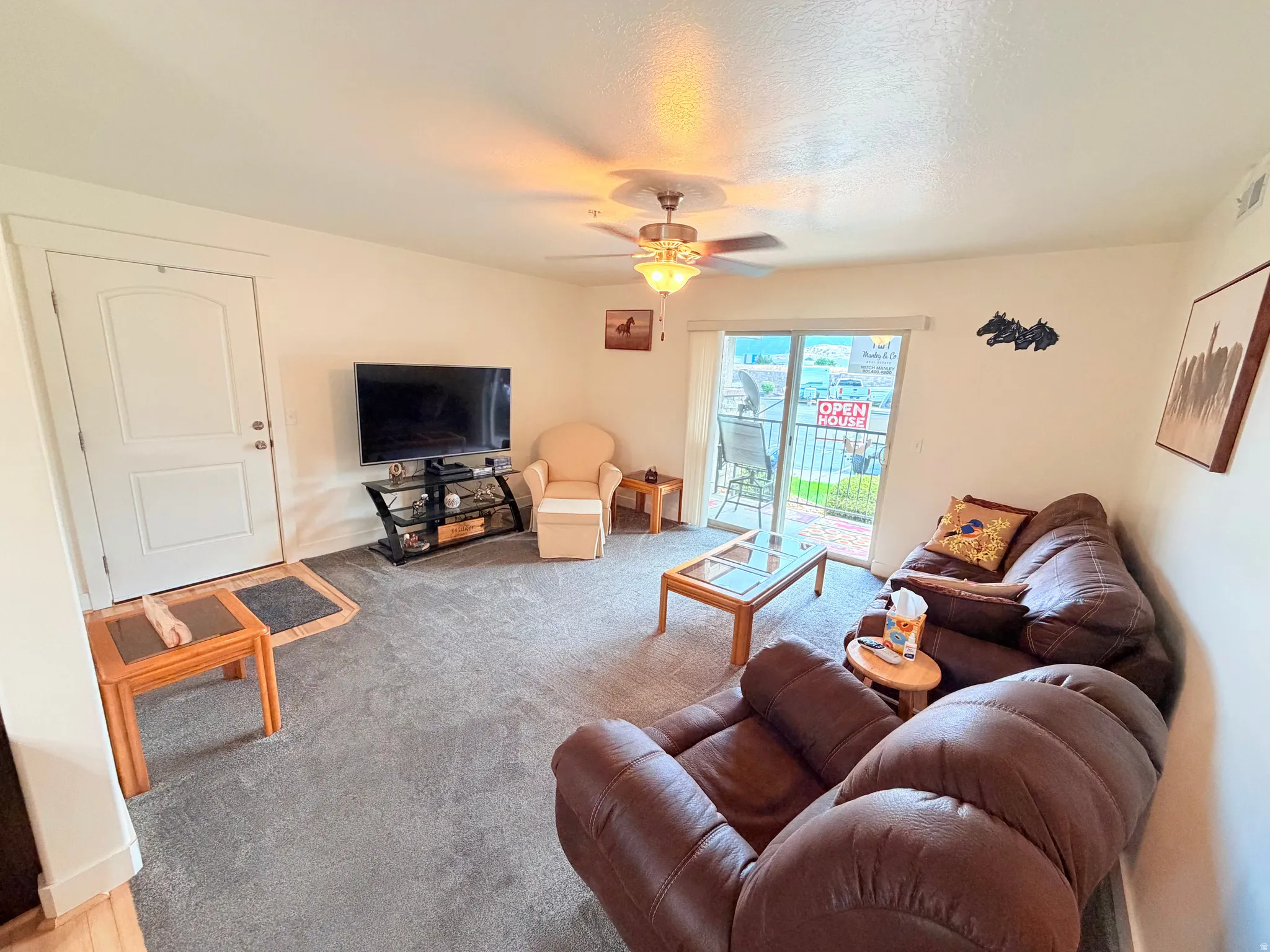 Living area featuring light-colored walls and grey carpet flooring