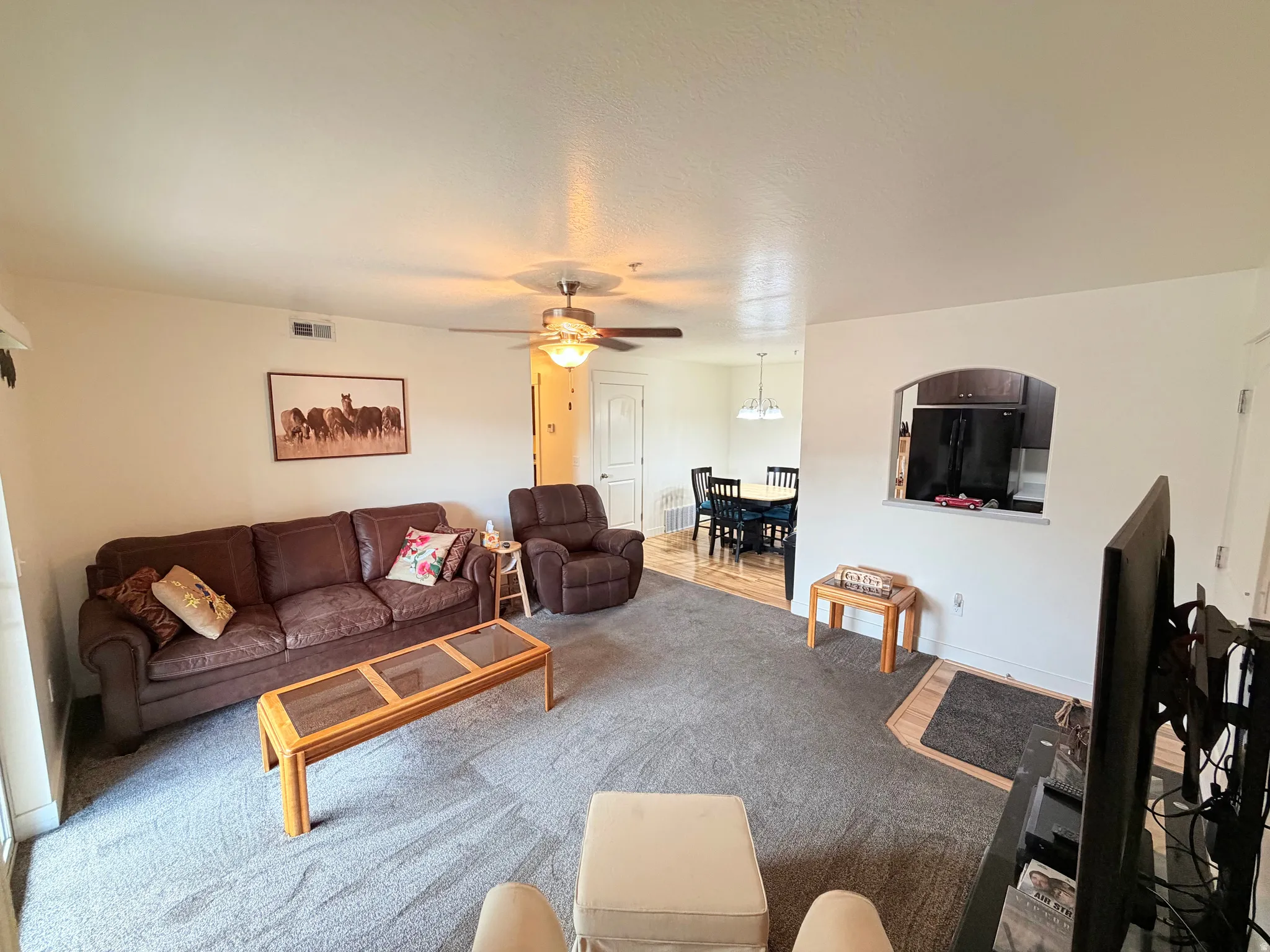 Expansive living area featuring carpet flooring, a ceiling fan, and recessed lighting