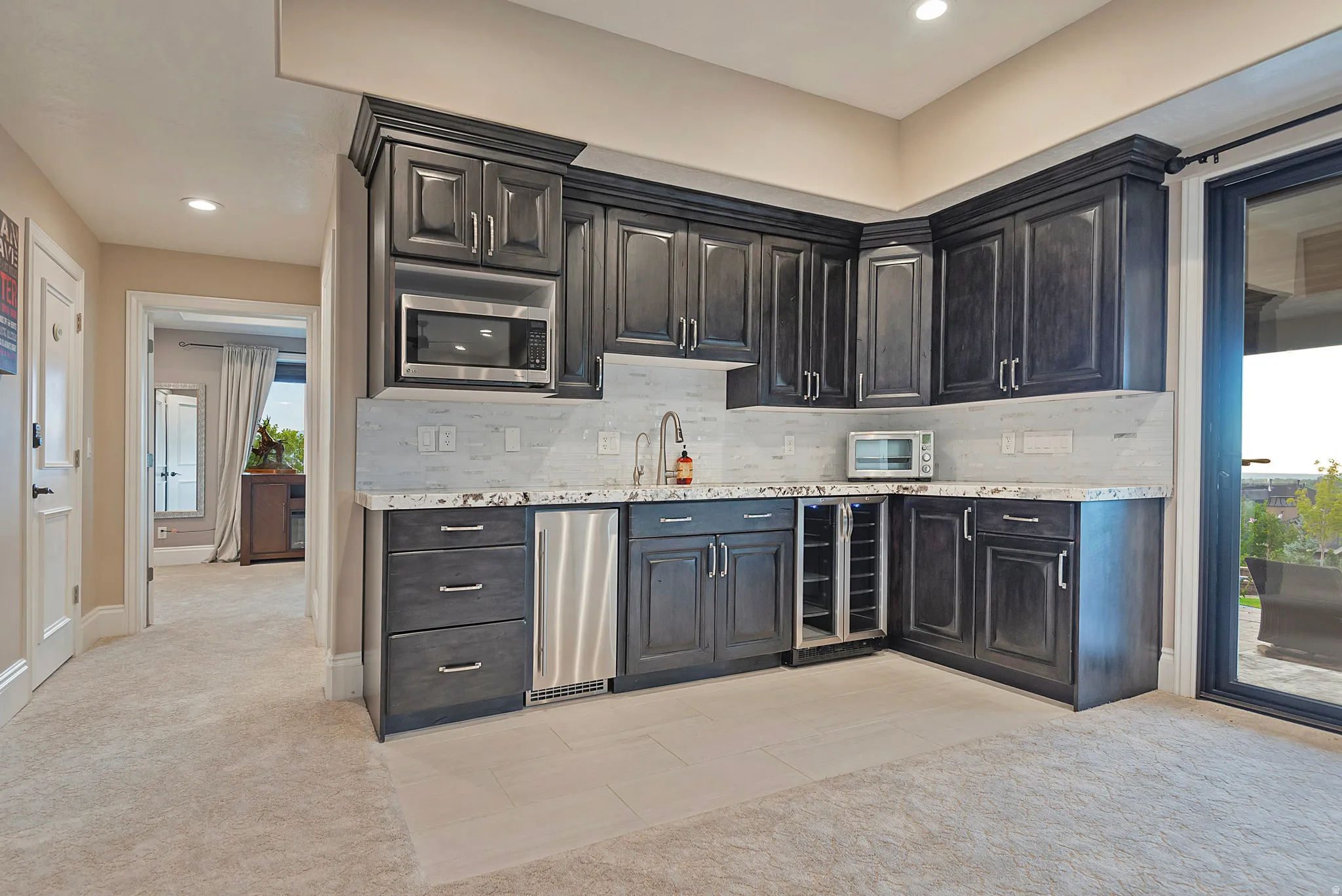 Kitchen with light carpet, light tile patterned floors, wine cooler, recessed lighting, and backsplash
