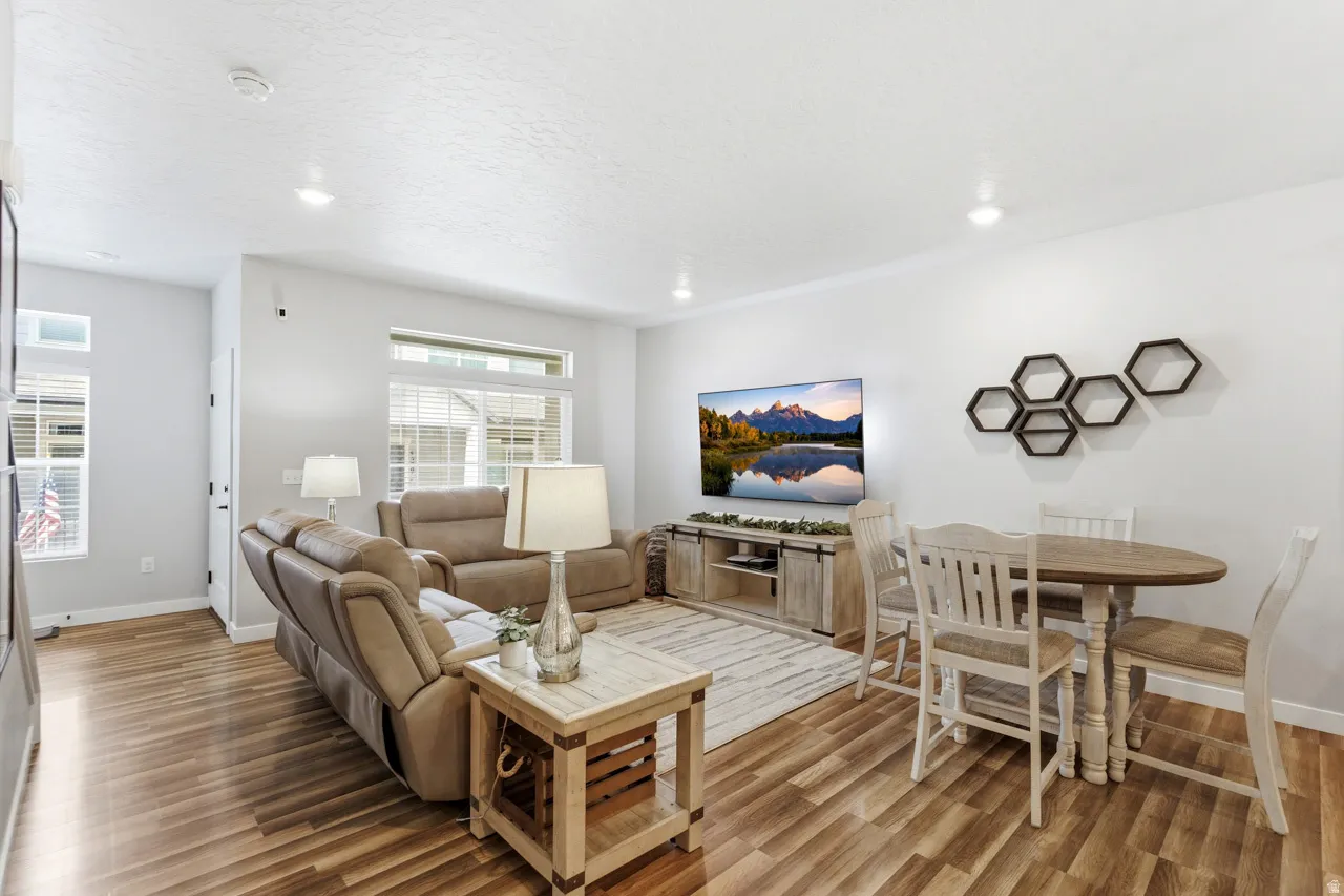 Living area with light wood-style flooring, recessed lighting, and a textured ceiling