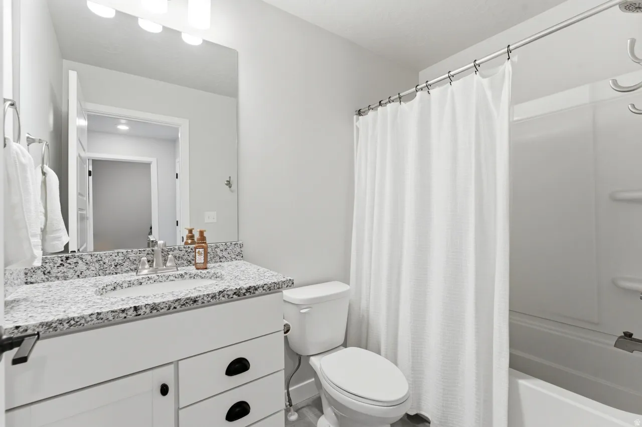 Bathroom with vanity and shower / tub combo with curtain