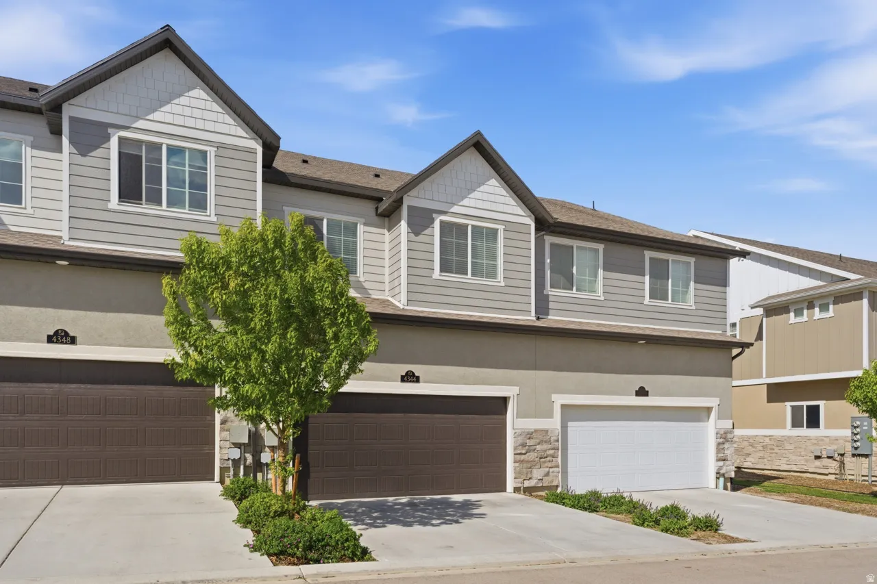 Craftsman house with stone siding, an attached garage, and driveway