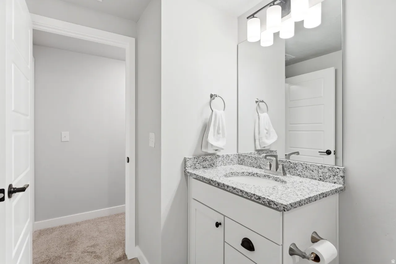 Bathroom with vanity and light carpet