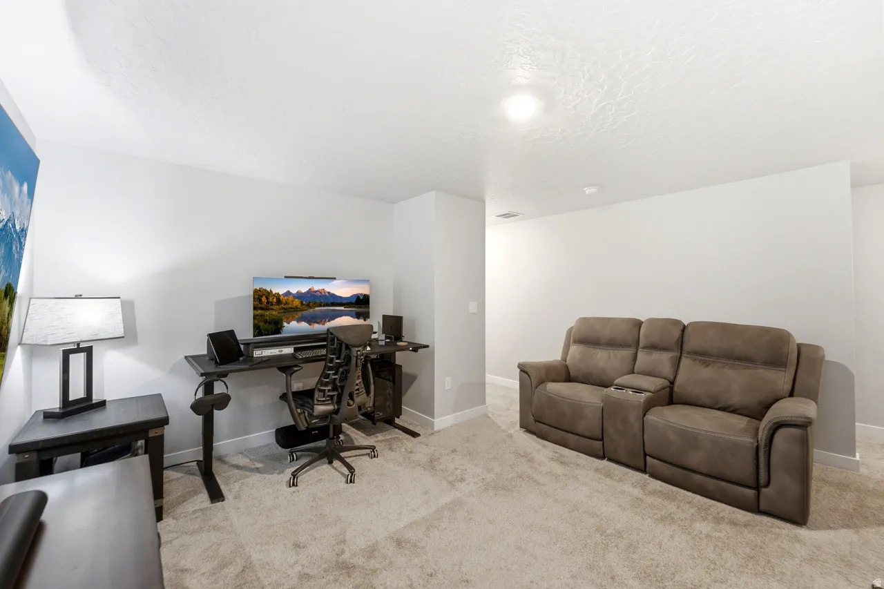 Home office featuring light carpet and a textured ceiling