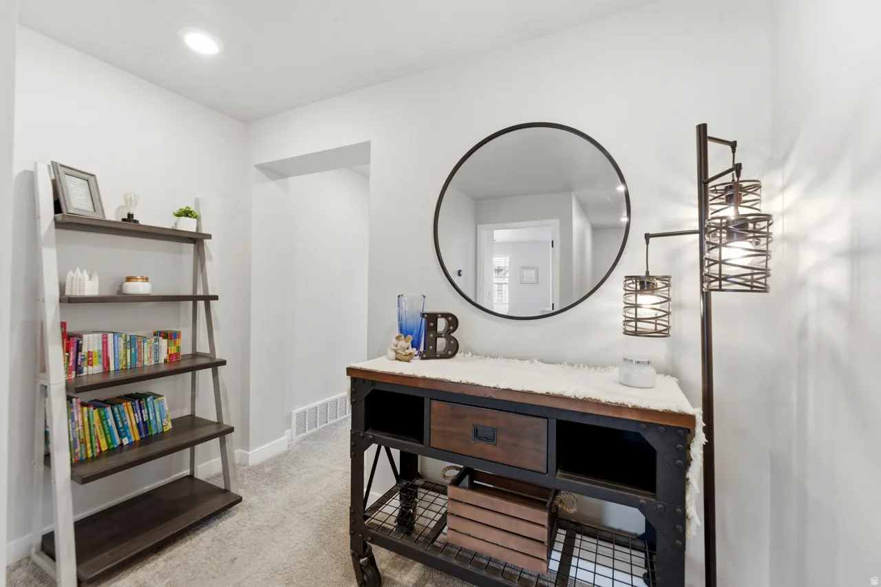 Bathroom with light colored carpet, vanity, and recessed lighting