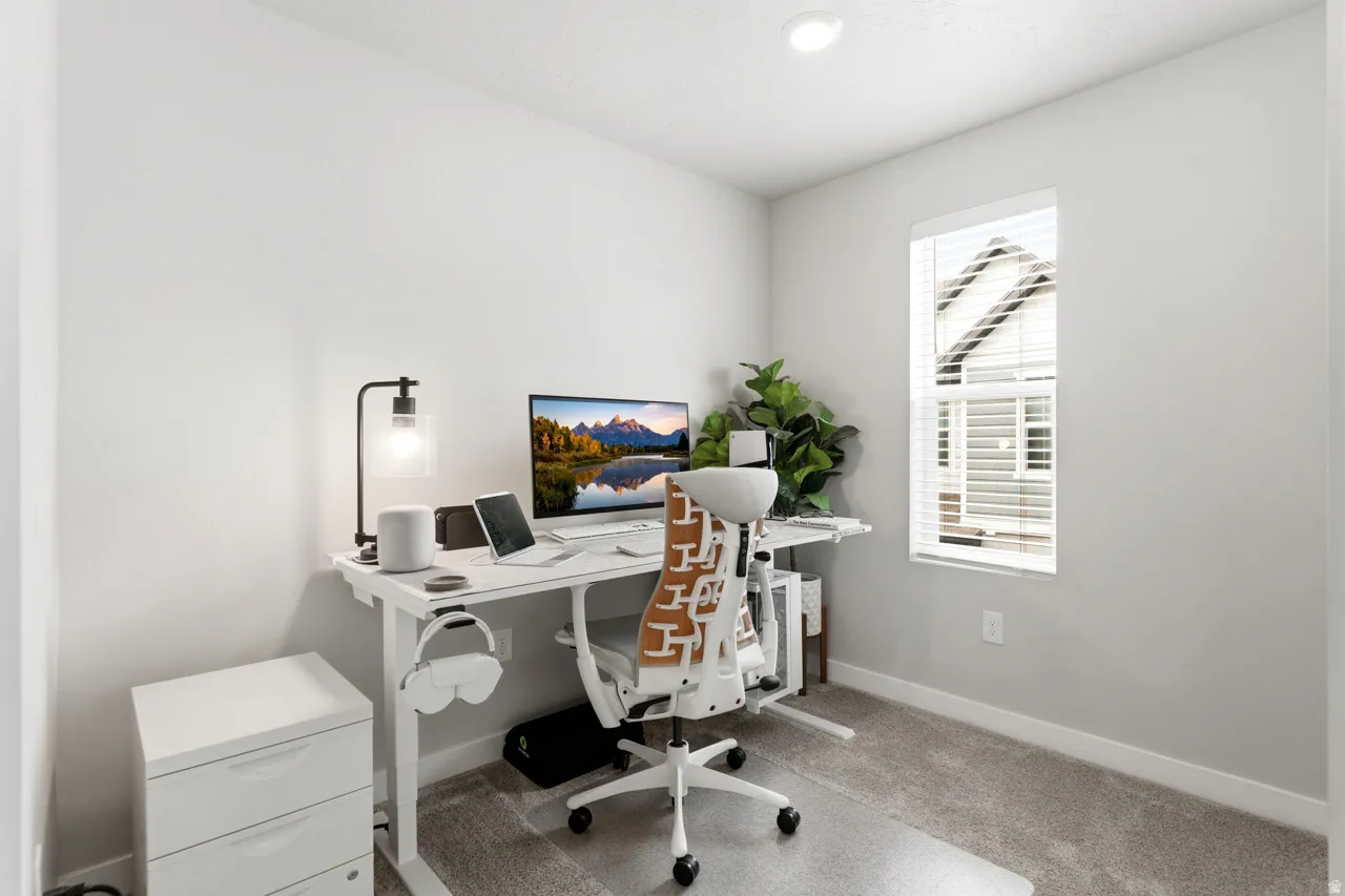 Home office featuring light colored carpet and baseboards