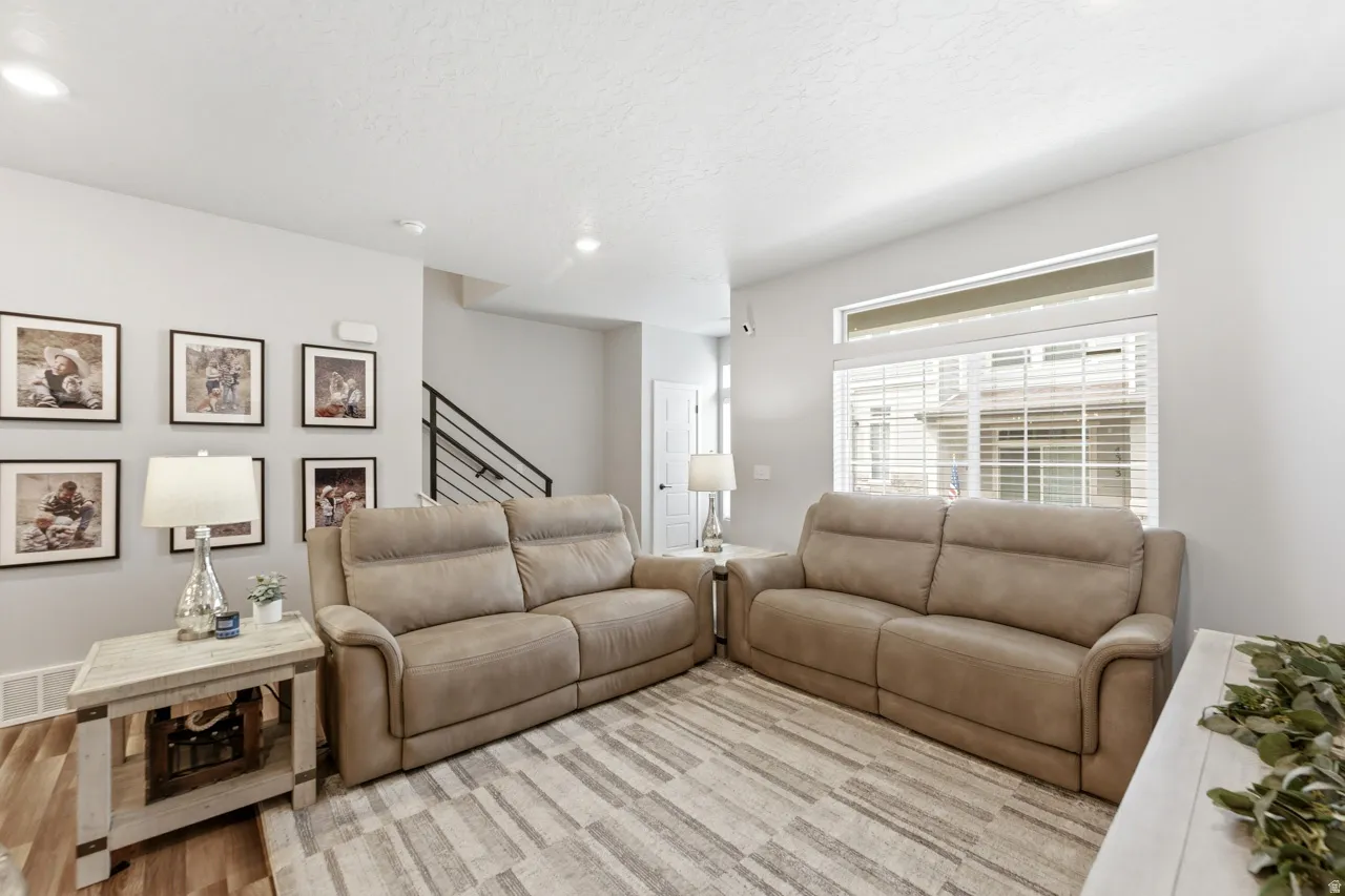 Living area with light wood finished floors and recessed lighting