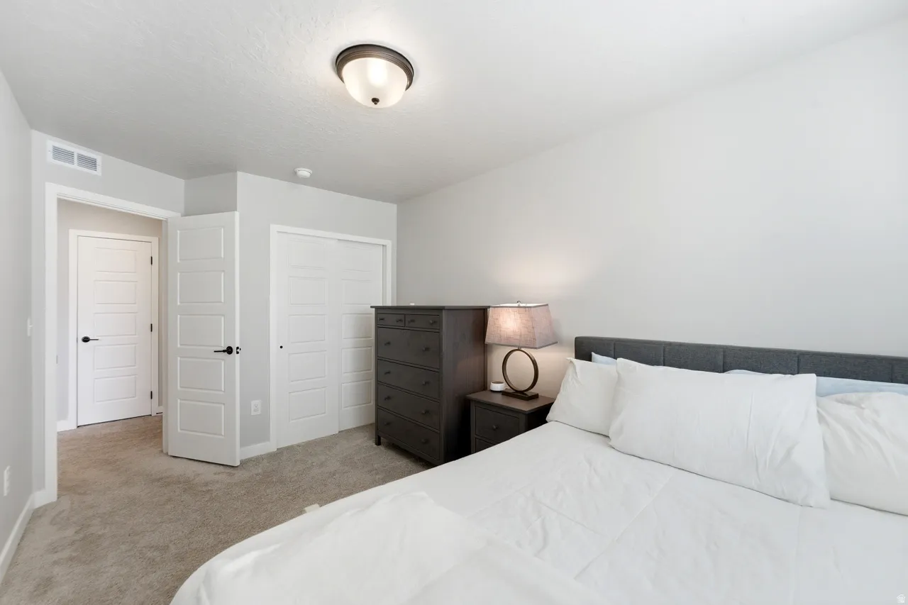 Bedroom featuring light colored carpet and a closet