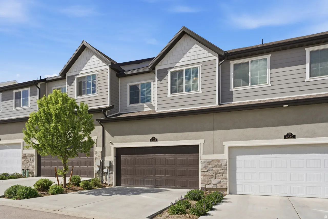Craftsman house with an attached garage, concrete driveway, stone siding, and stucco siding