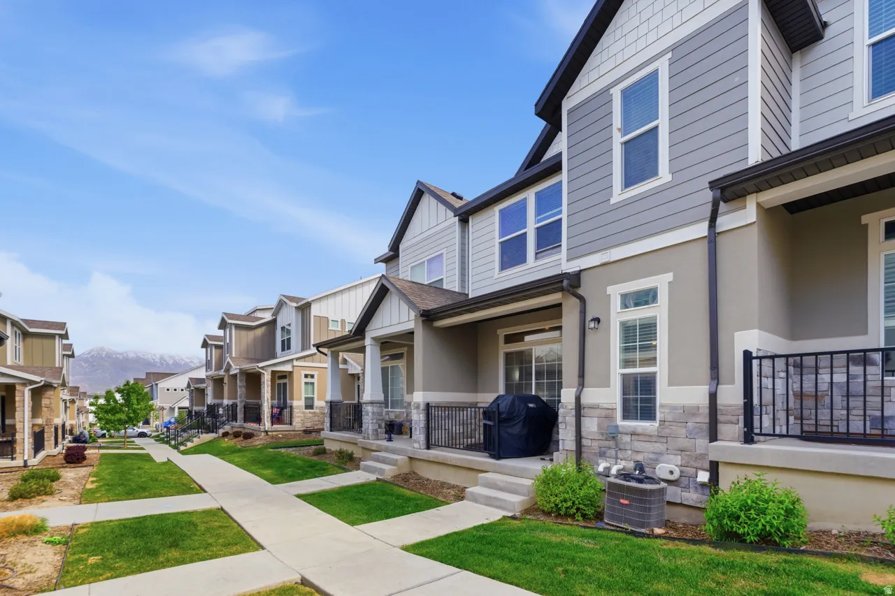 View of front of house with a residential view, stone siding, covered porch, board and batten siding, and a front yard
