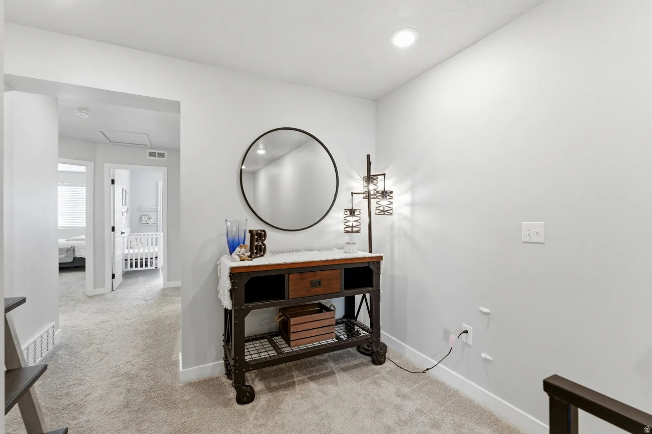 Bathroom with light colored carpet, vanity, and recessed lighting