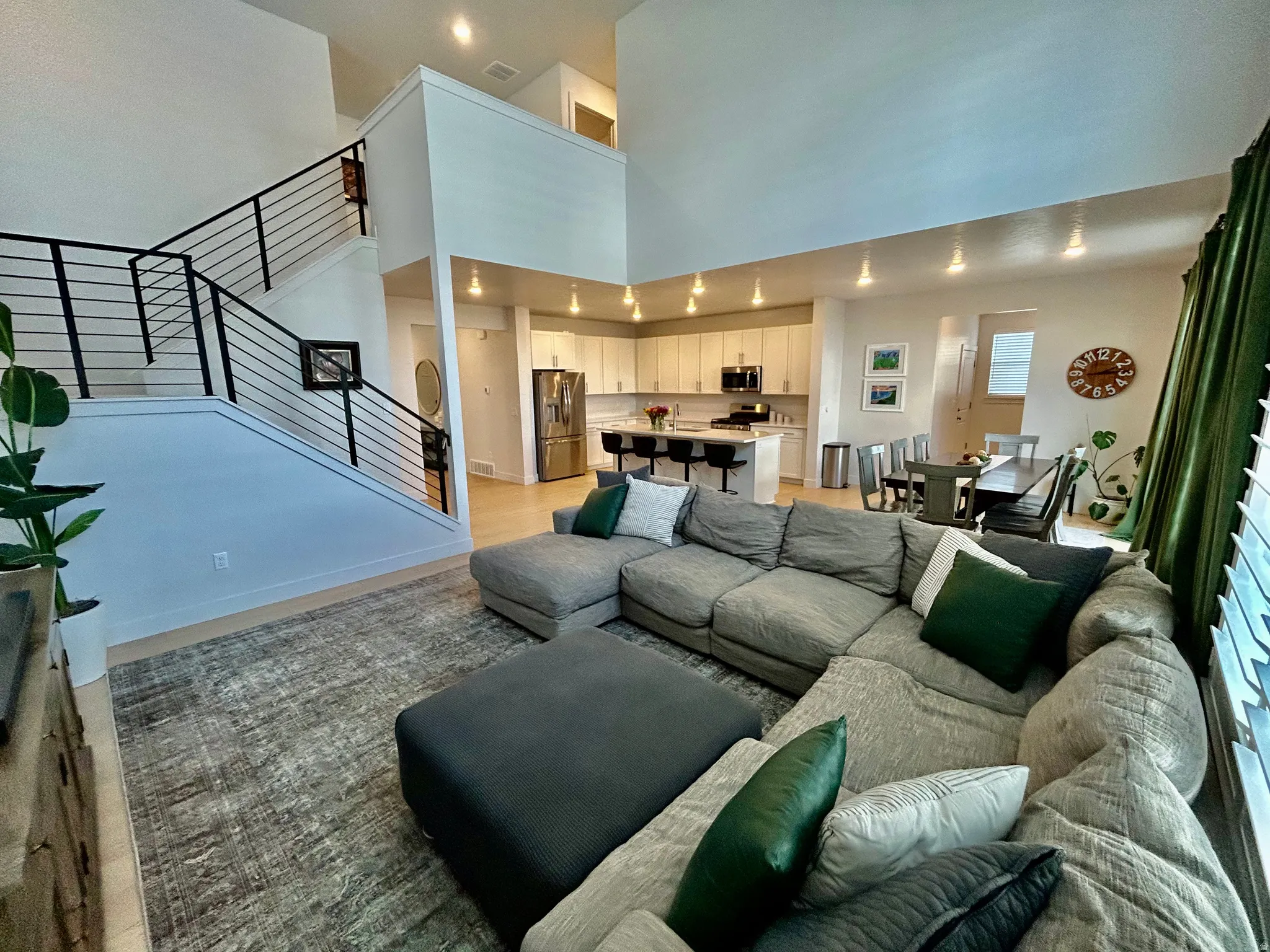 Living area with recessed lighting, light wood-style floors, and a high ceiling