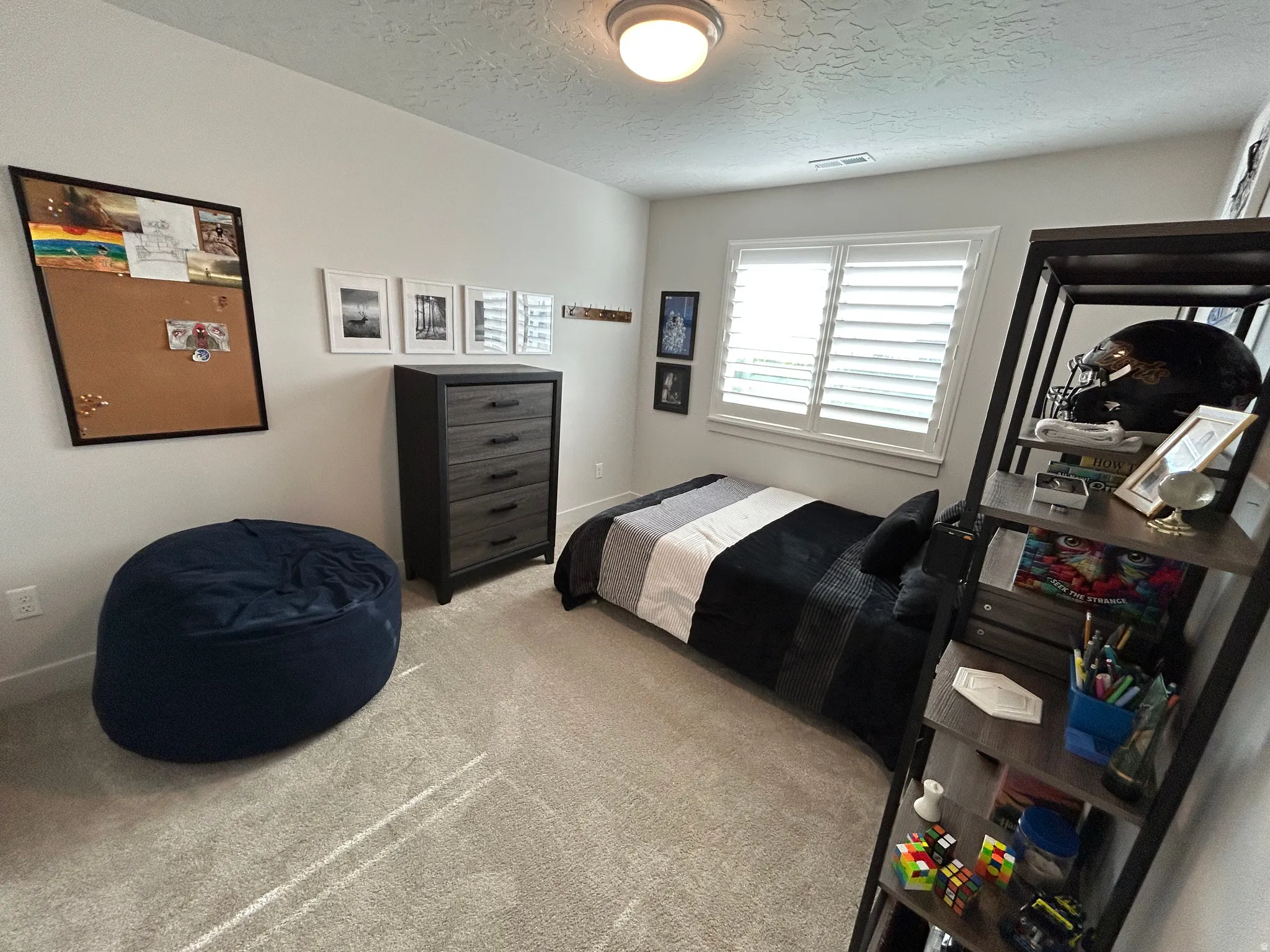 Bedroom with light carpet and a textured ceiling