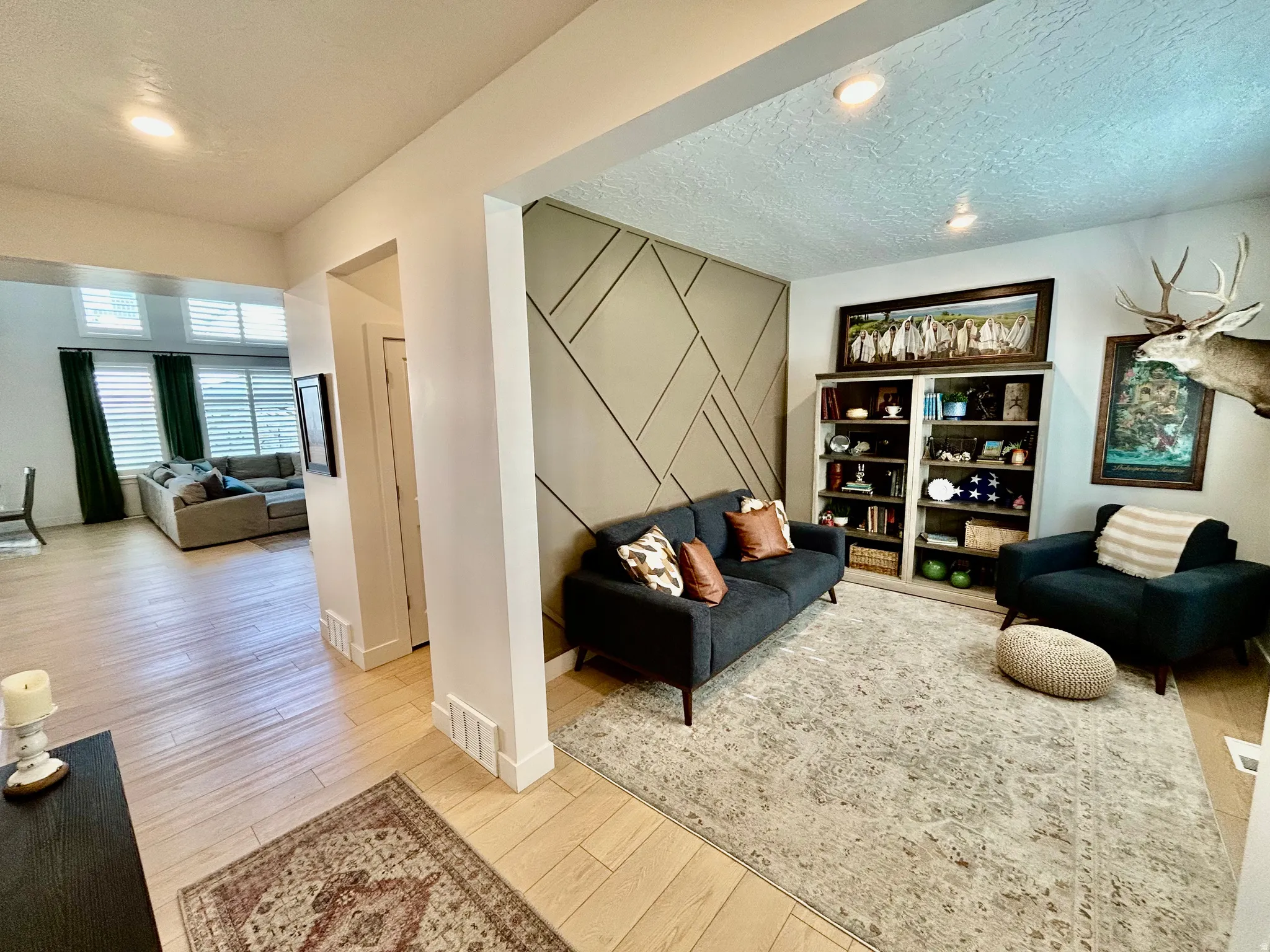 Living room featuring a textured ceiling, light wood finished floors, and recessed lighting