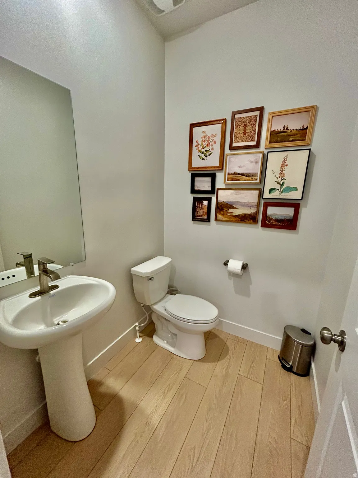 Half bathroom with light wood-style flooring and toilet