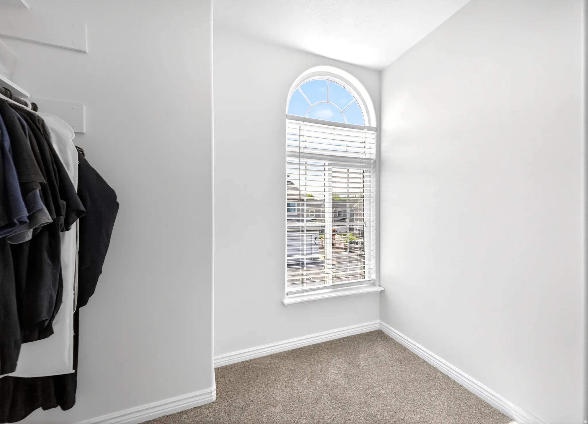 Walk in closet with dark carpet
