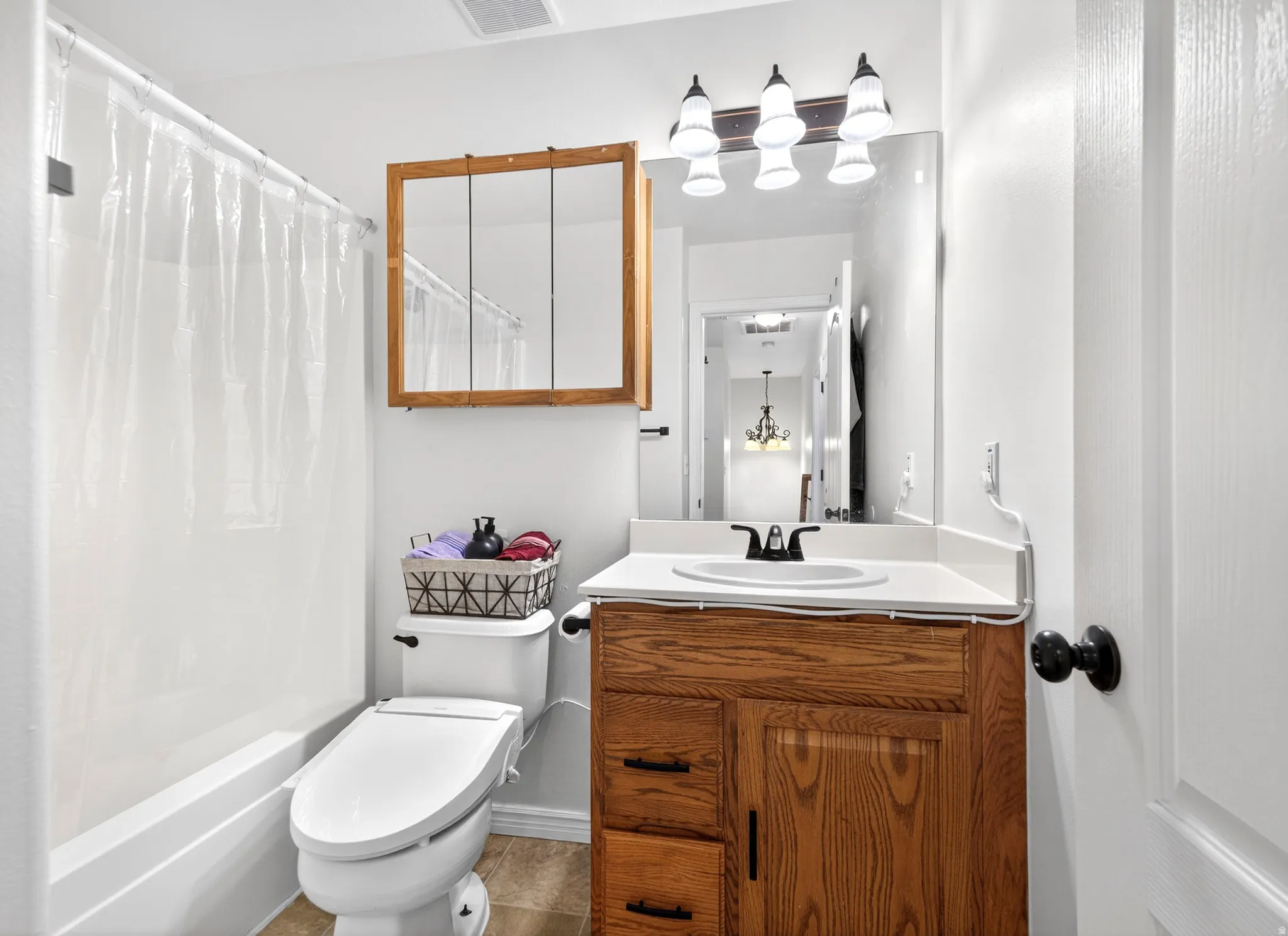 Bathroom with vanity and shower / bathtub combination with curtain
