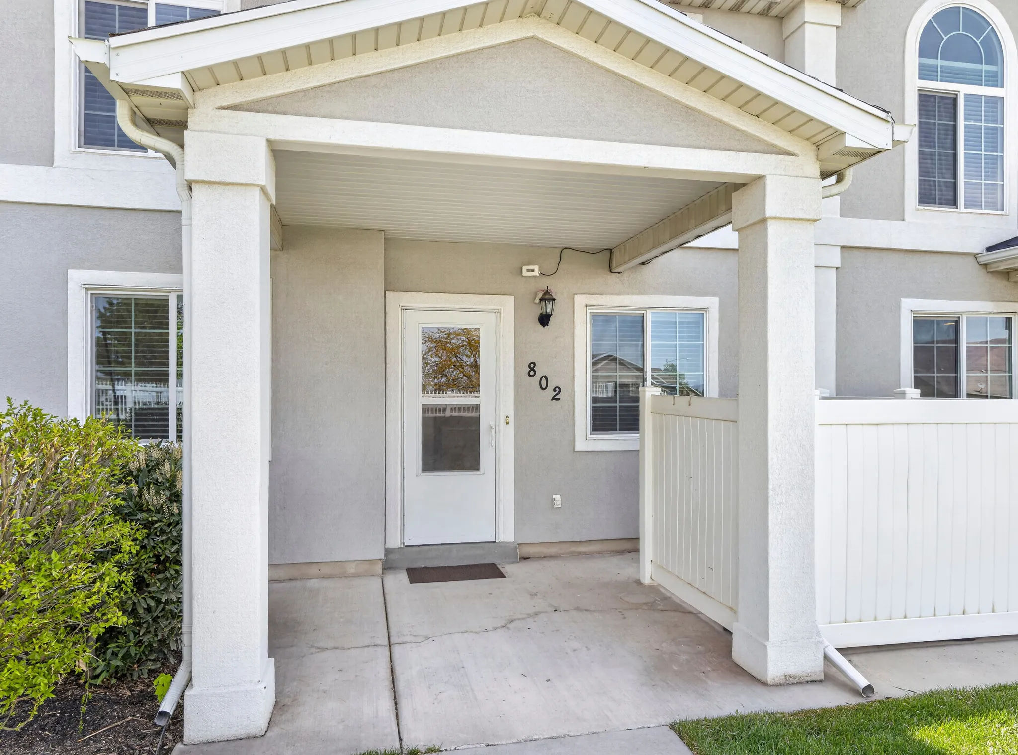 Entrance to property with covered porch and stucco siding