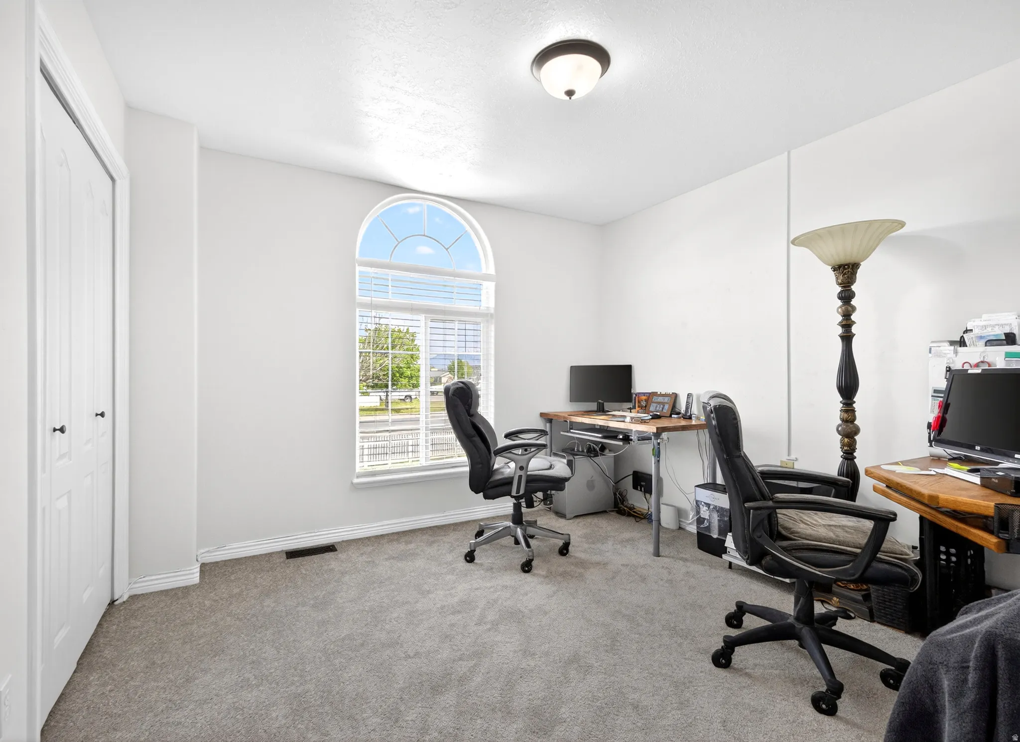 Office area featuring light colored carpet and baseboards