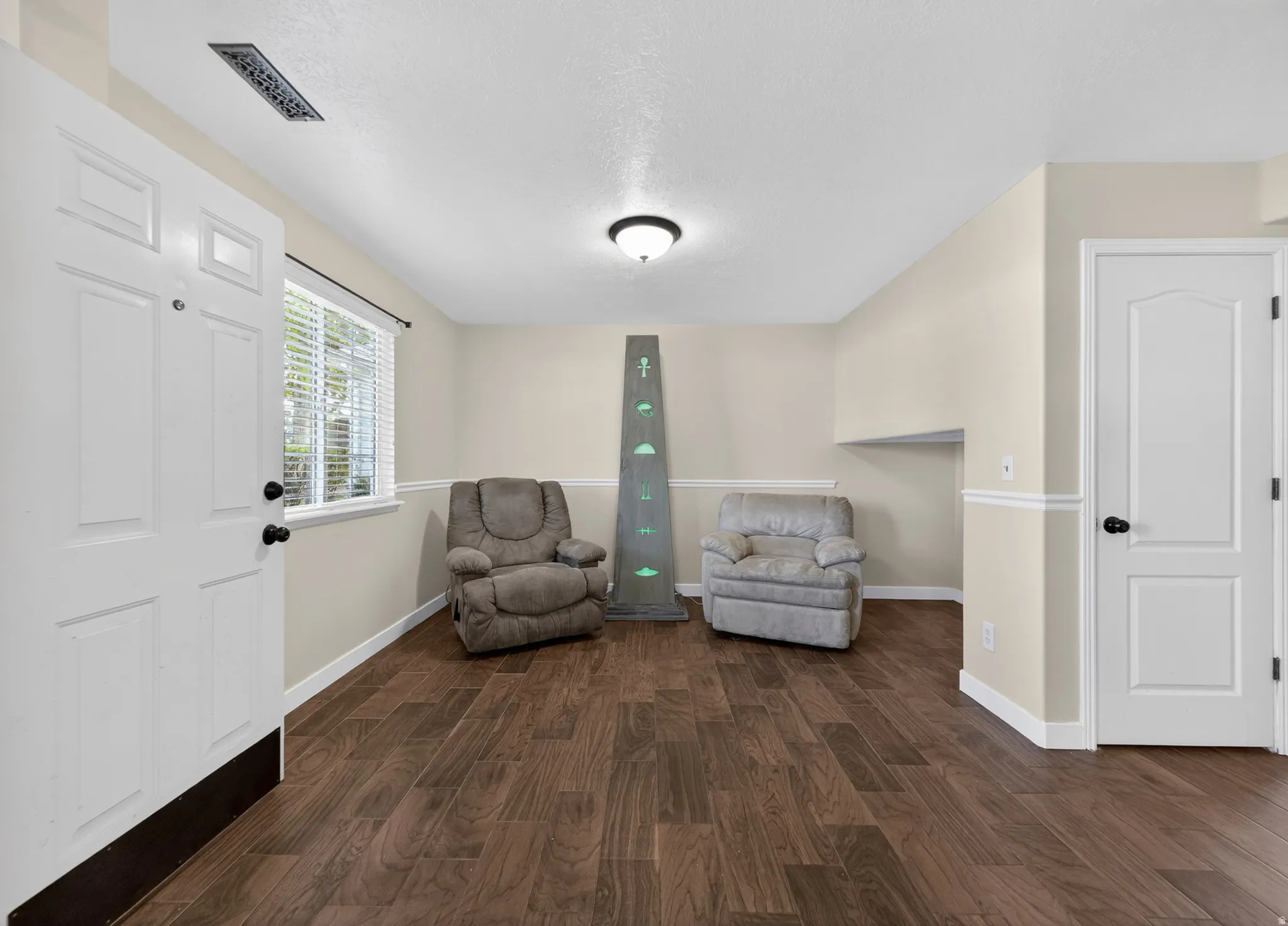 Living area featuring dark wood finished floors and a textured ceiling