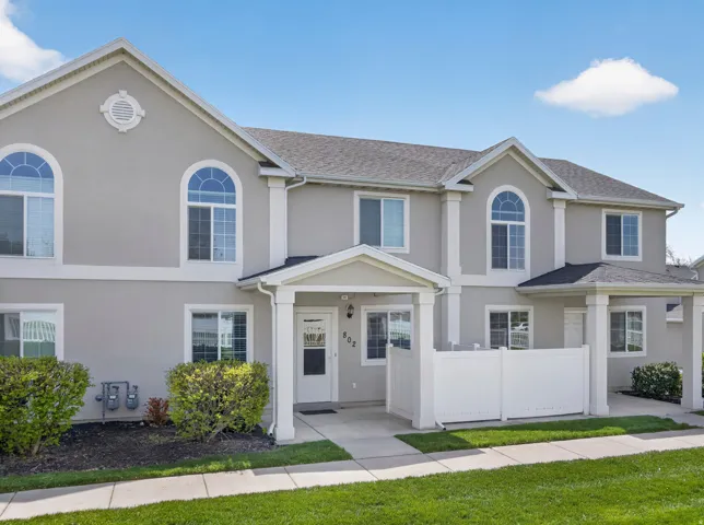 View of front of home featuring stucco siding and a shingled roof