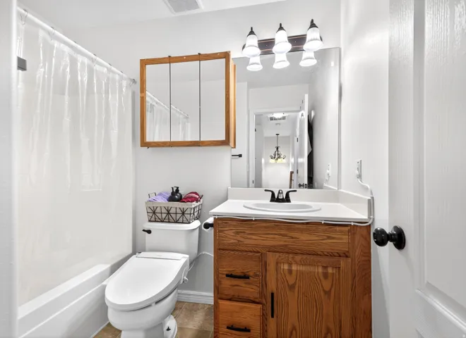 Bathroom with vanity and shower / bathtub combination with curtain