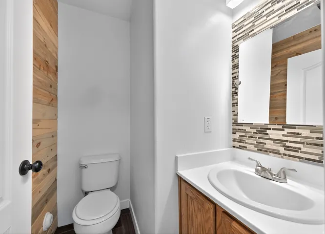 Half bath with vanity and decorative backsplash
