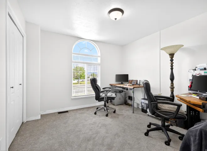 Office area featuring light colored carpet and baseboards