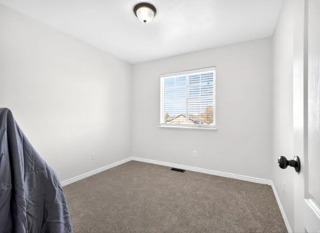 Empty room with dark carpet and baseboards