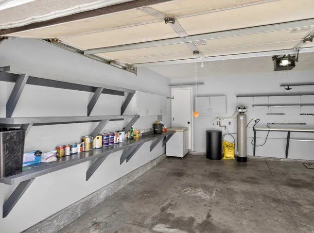 Garage with white fridge and a garage door opener