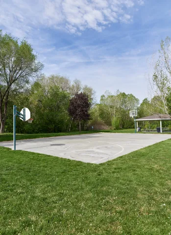 View of sport court with a lawn and community basketball court