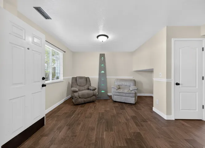 Living area featuring dark wood finished floors and a textured ceiling