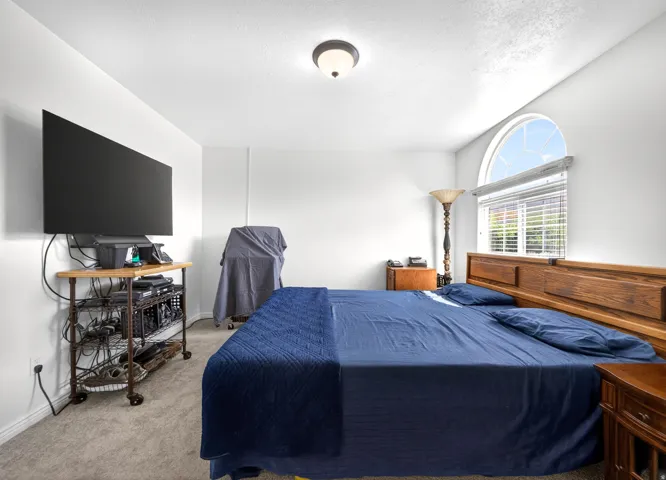 Carpeted bedroom featuring baseboards and a textured ceiling