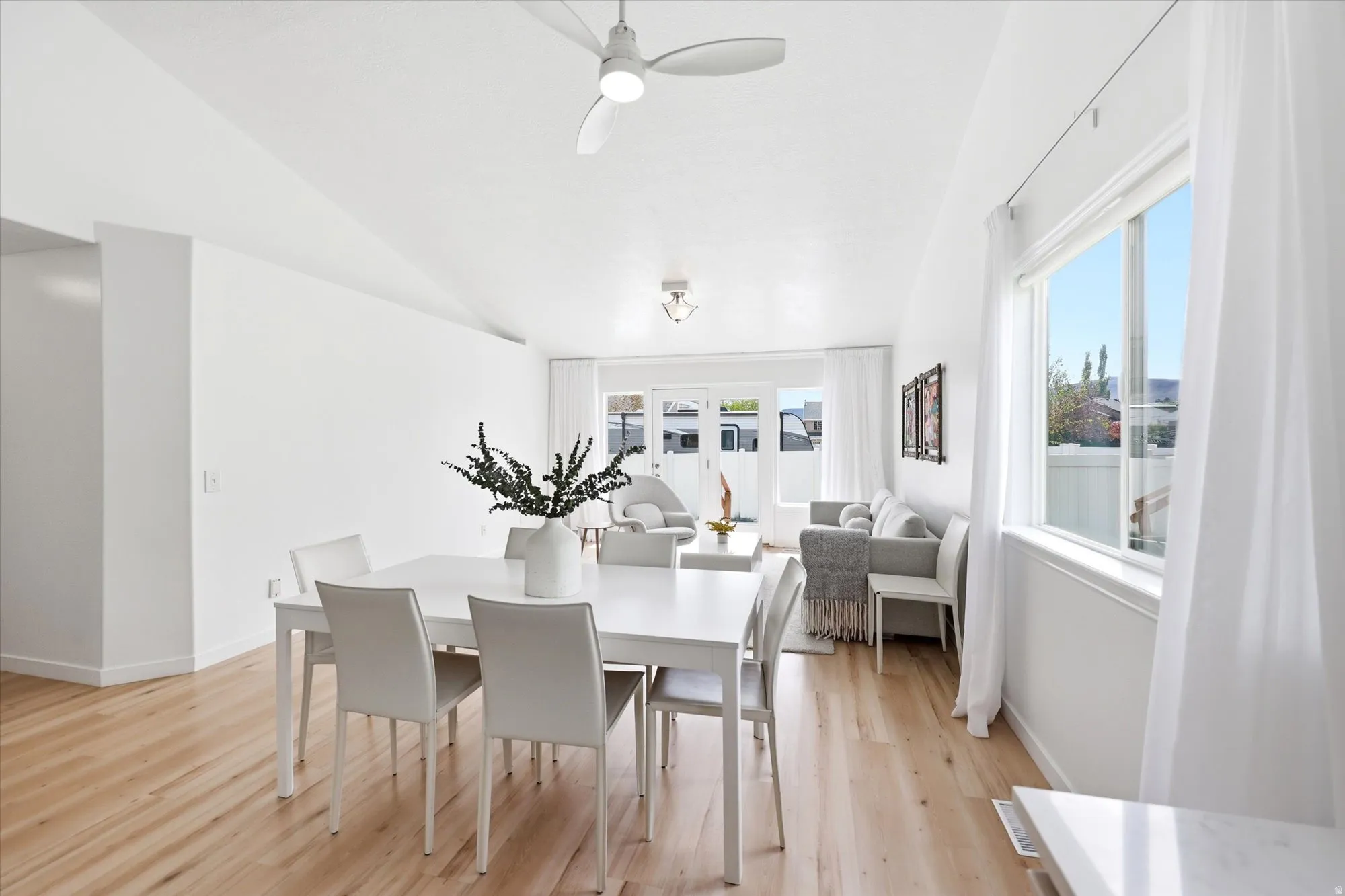 Dining area with light wood-style floors, ceiling fan, healthy amount of natural light, and lofted ceiling